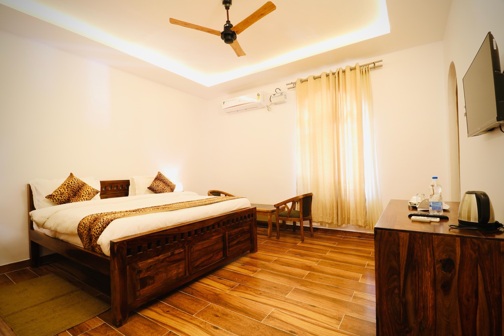 OmVana guest room with wooden bed and AC